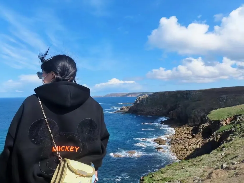 学员在海边徒步的背影与海岸风景